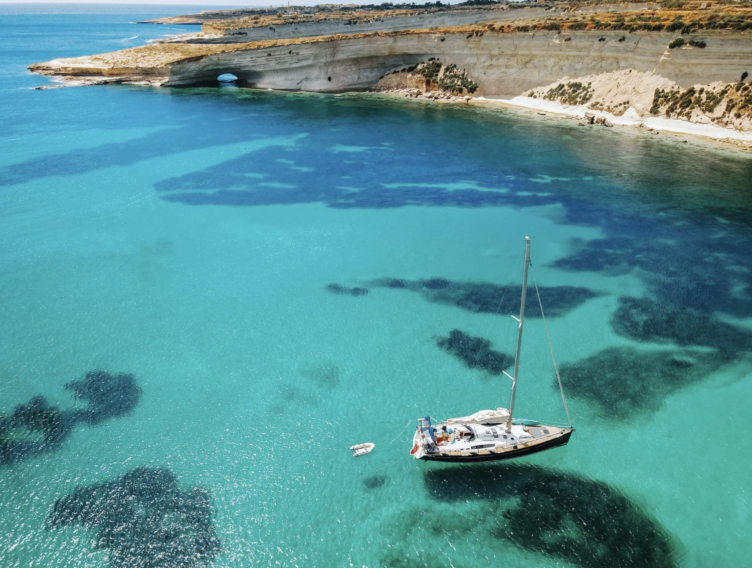 ACE at anchor over turquoise water, seen from above